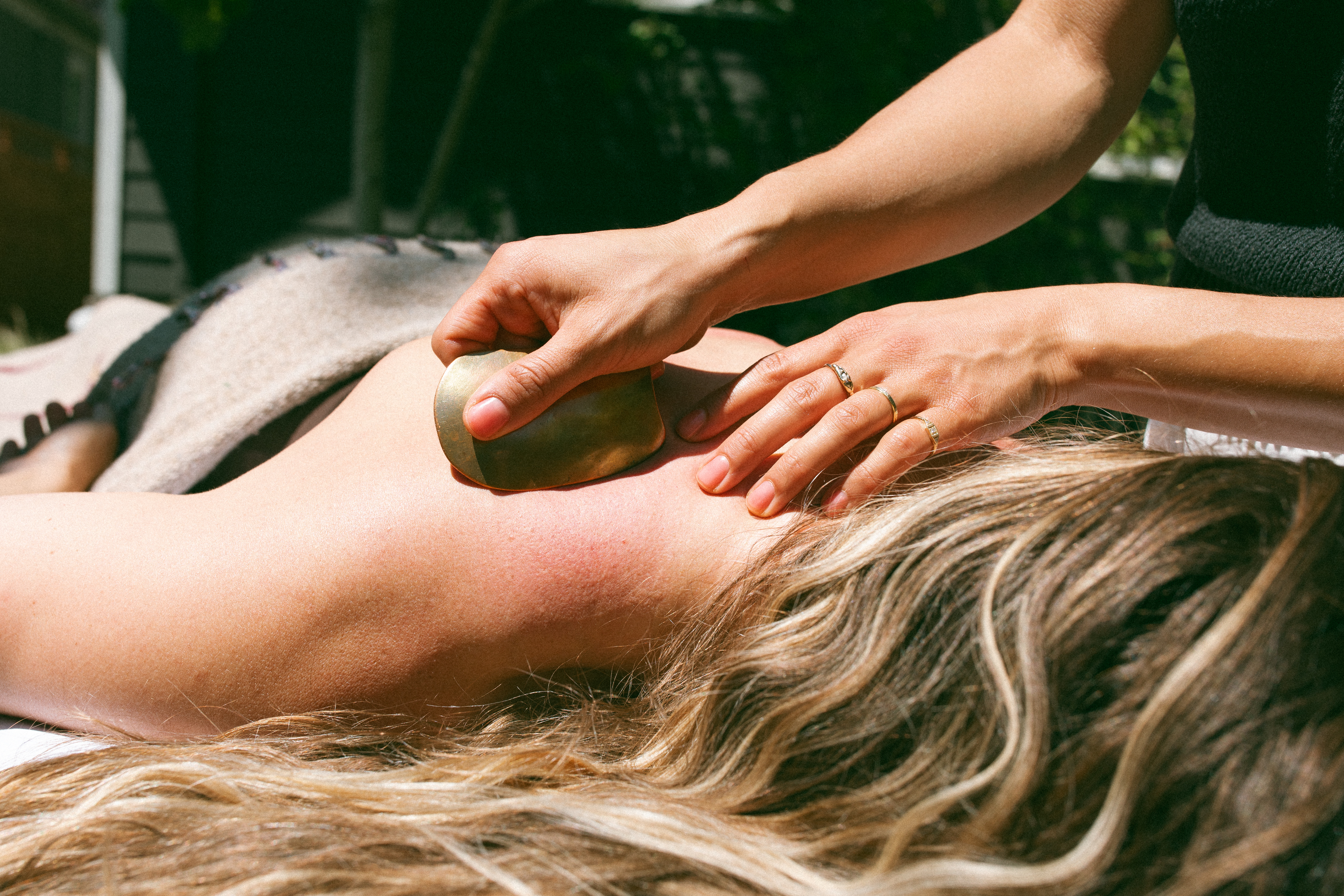Dr. Sarah Swanson providing gua sha during an outdoor treatment visit.